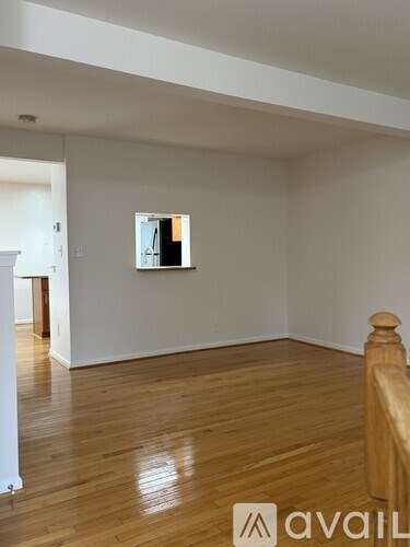 A room with wooden floors and a mirror on the wall.