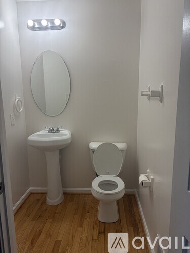 A small white bathroom with a toilet, sink and mirror.