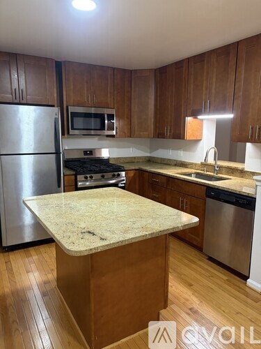 A kitchen with wooden cabinets and a granite countertop.