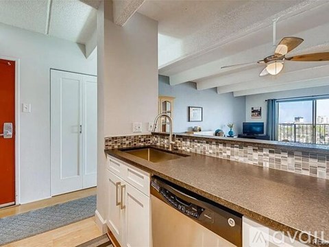A kitchen with a red door and a stainless steel dishwasher.