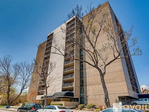 A tall building with a tree in front of it.