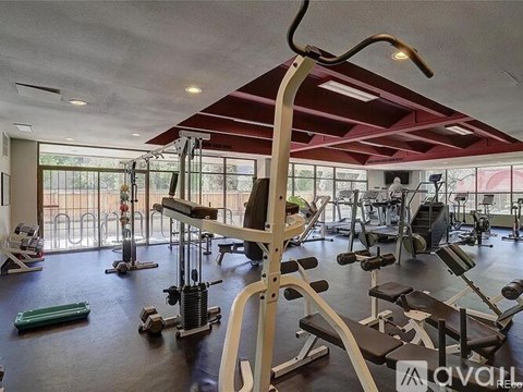 A gym with a variety of equipment including weights and a leg press machine.