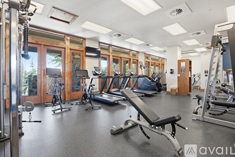A gym with a variety of equipment including treadmills, weights, and exercise machines.