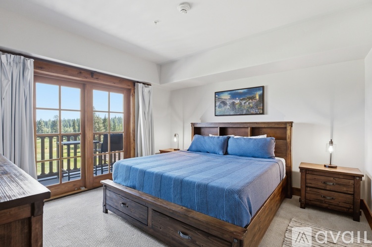 A bedroom with a large bed and a balcony.