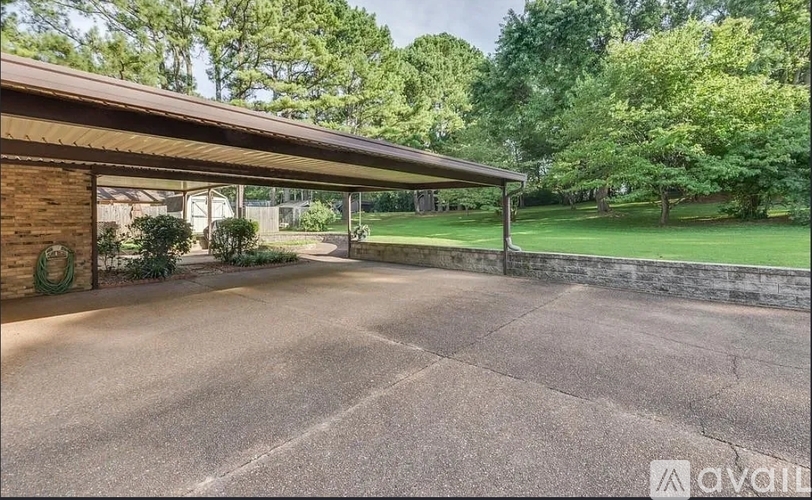 A driveway leads to a house with a garage door.