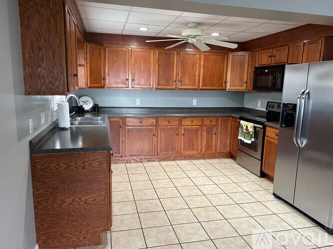A kitchen with wooden cabinets and a tile floor.