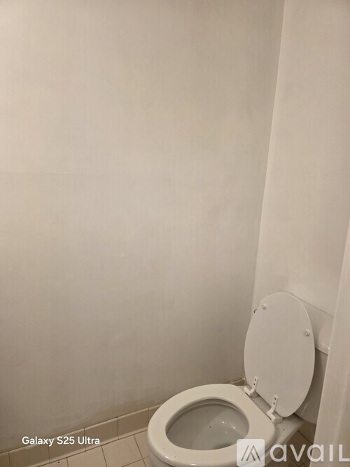 A white toilet with the text "Galaxy S25 Ultra" and "Avail" on the wall.