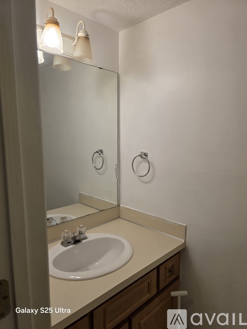 A bathroom with a Galaxy S25 Ultra phone on the counter.