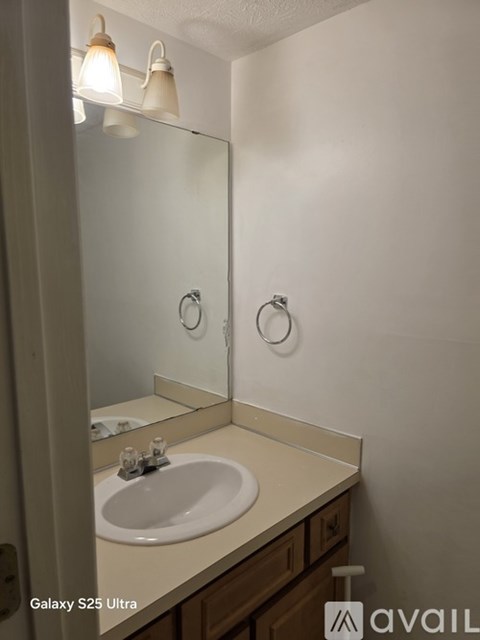 A bathroom with a Galaxy S25 Ultra phone on the counter.