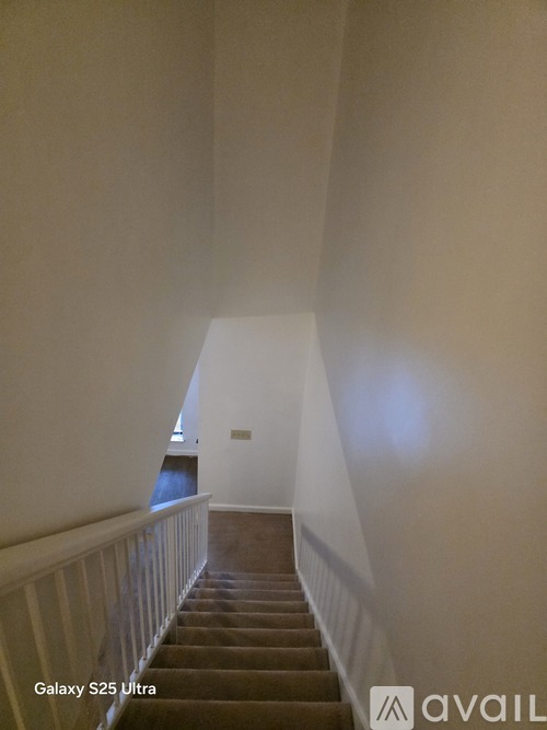 A staircase with a carpeted runner and white balustrade.