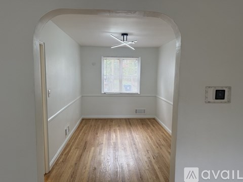 A room with wooden floors and a window with blinds.