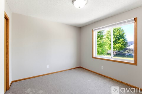 A room with a window showing trees outside.