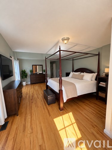 A bedroom with a four poster bed and a television.