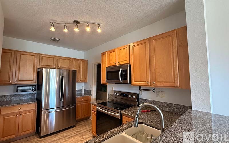A kitchen with wooden cabinets and stainless steel appliances.