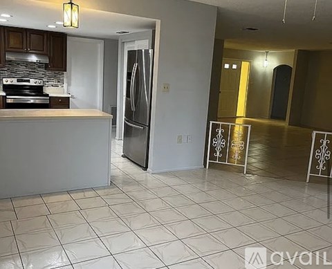 A kitchen with a refrigerator, stove, and sink.