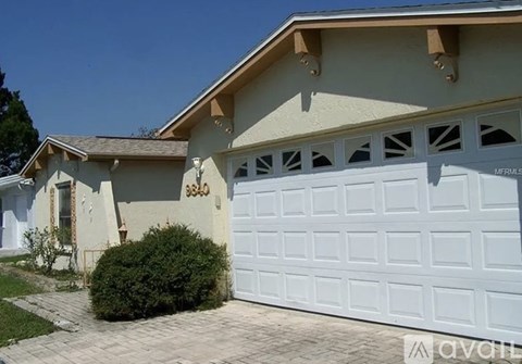A house with a white garage door and a brown roof.