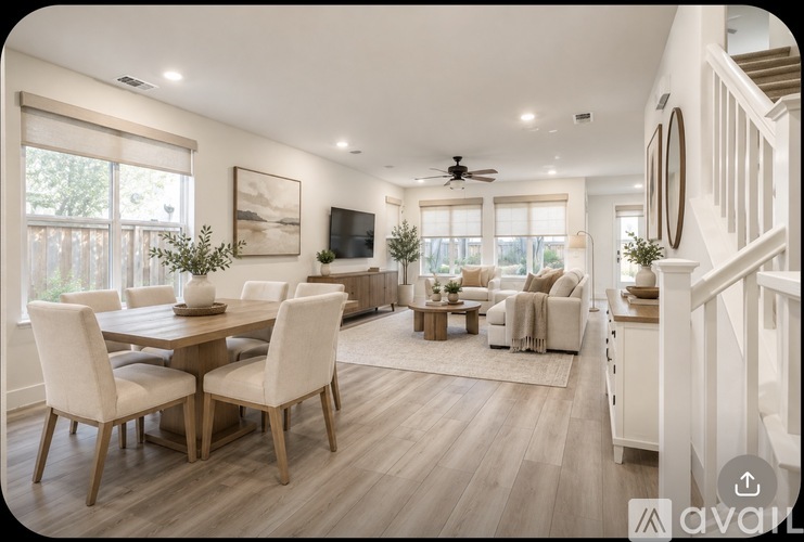A well-lit, spacious living room with a dining table and chairs.