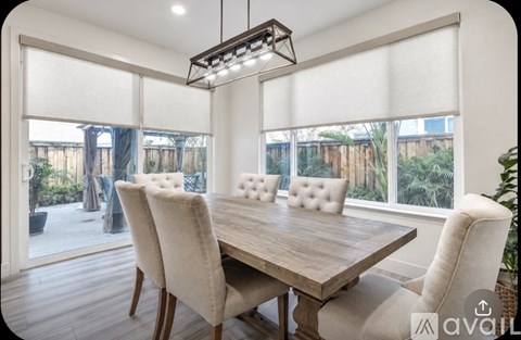 A dining room with a wooden table and chairs.