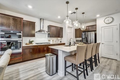 A modern kitchen with a large island and bar stools.