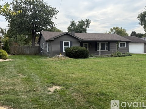A house with a grey roof and a white garage door.