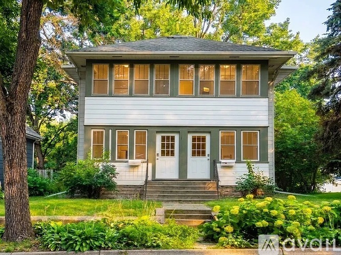 A two-story house with a white door and windows.