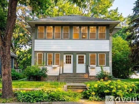 A two-story house with a white door and windows.
