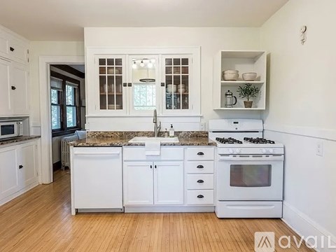 A kitchen with white cabinets and a granite countertop.
