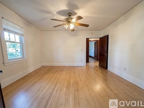 A room with wooden floors and a ceiling fan.