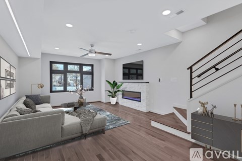 A modern living room with a grey sofa and a wooden floor.