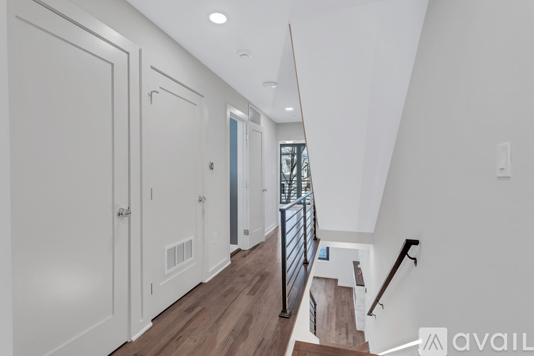 A hallway with a staircase and a railing.