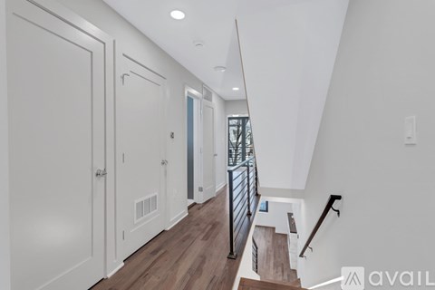 A hallway with a staircase and a railing.