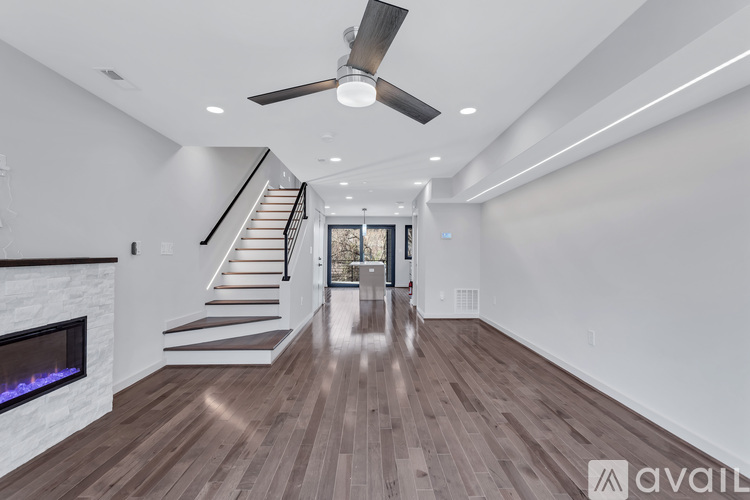 A spacious room with a staircase leading to the upper level.