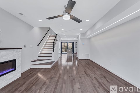A spacious room with a staircase leading to the upper level.