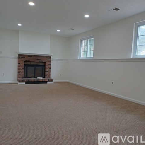 A living room with a fireplace and carpeted floor.