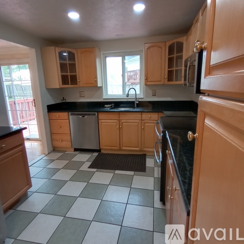 A kitchen with wooden cabinets and black countertops.