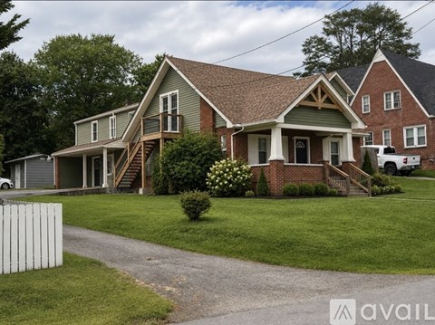 A house with a green front yard and a white picket fence.