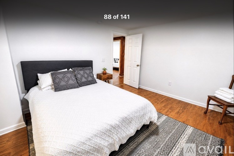 A bedroom with a large bed and a chair.