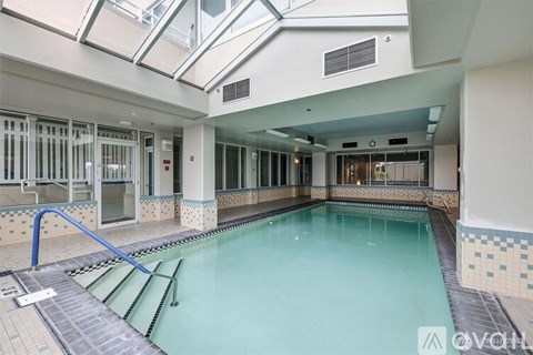 A large indoor swimming pool with a skylight above it.