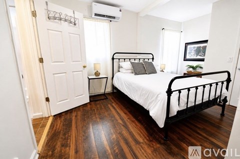 A bedroom with a black metal bed frame and white bedding.