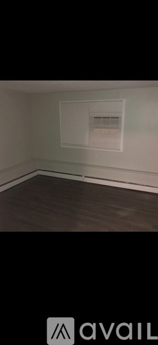 A room with a white wall and a window.