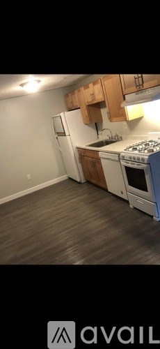 A kitchen with wooden cabinets and a white refrigerator.