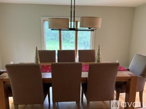 A dining room with a table and chairs.