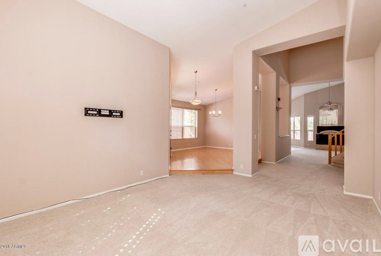 A spacious room with a sign on the wall and a hallway leading to another room.