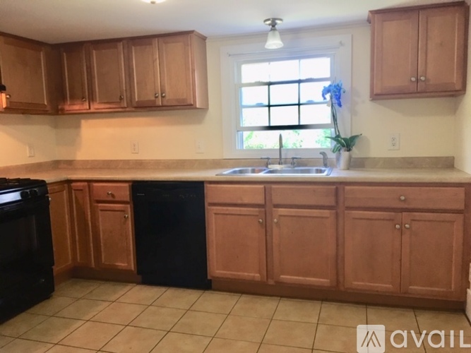 A kitchen with wooden cabinets and black appliances.