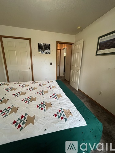 A bedroom with a bed covered in a quilt with star patterns on it.