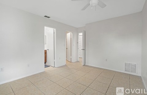 A spacious room with a fan and tiled flooring.