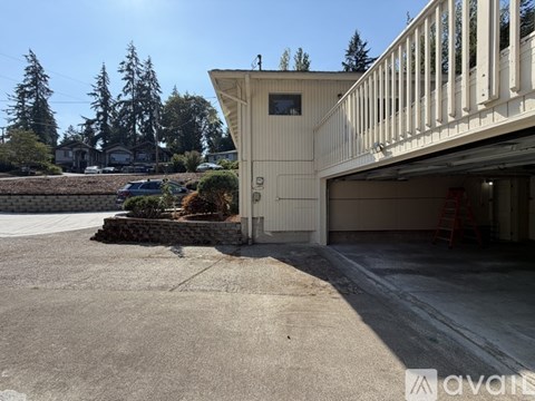 A large garage with a white exterior is situated in a driveway.