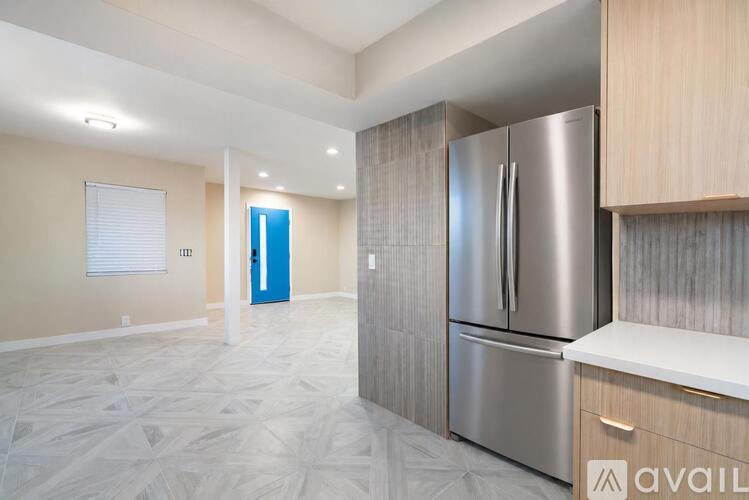 A kitchen with a refrigerator, cabinets, and a countertop.