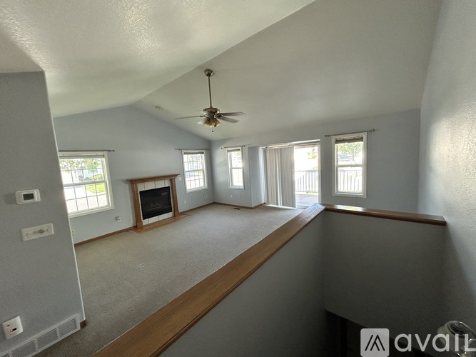A spacious room with a ceiling fan and large windows.