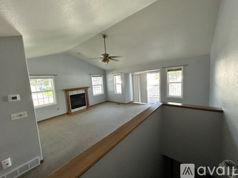 A spacious room with a ceiling fan and large windows.